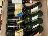 plusieurs bouteilles de vin dans un carton posé sur le sol