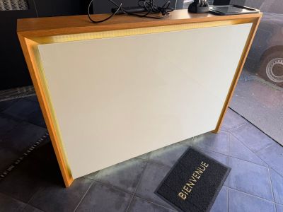 a white counter with a black door and a black door mat