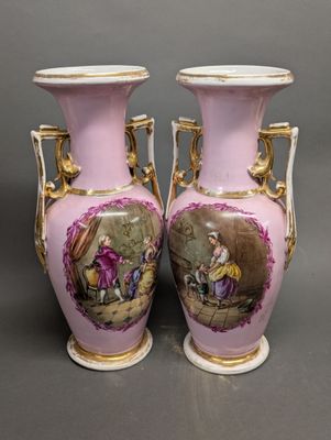 une paire de vases roses et dorés ornés d'une peinture représentant un homme et une femme