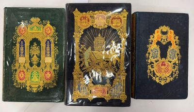 trois livres sont alignés sur une surface blanche