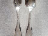 deux cuillères et une fourchette en argent sur une table