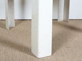 a close up of the legs of a white table with a black top