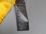 a close up of a yellow scarf with a tag on it