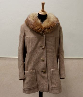 coat on a mannequin stand with a fur collar
