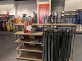 a display of clothes in a clothing store with clothes on the shelves