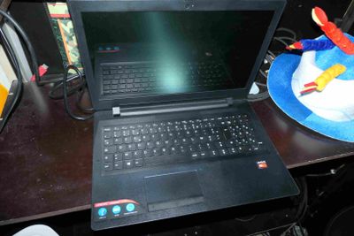 un ordinateur portable posé sur un bureau, à côté d'une assiette sur laquelle se trouve un gâteau