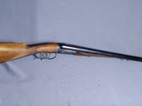 un fusil avec un canon en bois et un embout métallique, sur fond blanc
