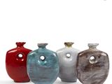 four different colored vases sitting next to each other