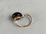 a close up of a gold ring with a black stone on it