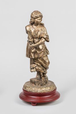 une figurine antique en bronze représentant une femme tenant un enfant dans ses bras