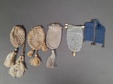 several small crocheted bags are lined up on a table