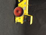 a yellow toy truck with a red light on it