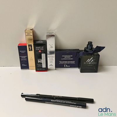 un flacon de liquide, un stylo et une boîte de mascara posés sur une table