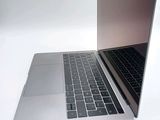 a silver laptop with a black keyboard on a white surface