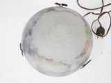 underside view of a white marble lamp with a brown cord on a white surface