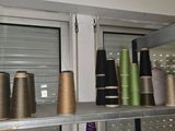 many spools of thread on a shelf in a room
