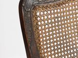a brown chair with a wicker back and a wooden seat