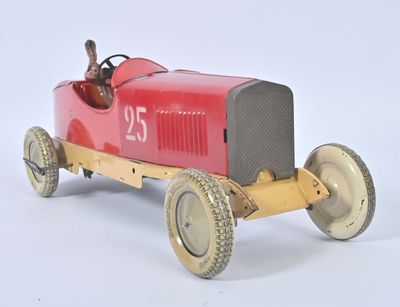 une petite voiture rouge avec un homme assis au volant