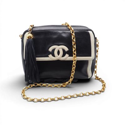 un sac Chanel noir et blanc avec une chaîne dorée