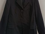 black blazer jacket hanging on a wall in a white room