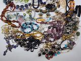 a pile of assorted jewelry on a white surface