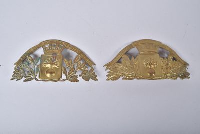 une paire d'insignes en métal doré représentant un homme et une femme