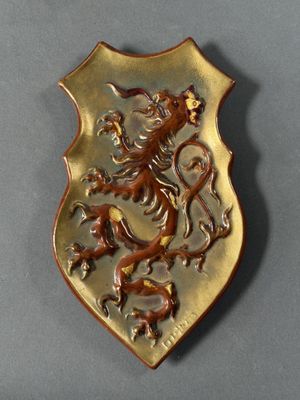 a gold plate with a lion on it on a gray surface