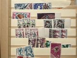 a refrigerator covered in stamps and magnets on the wall