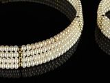 two pieces of white and black beaded bracelets on a black surface
