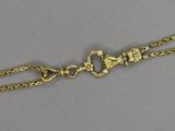 a close up of a gold chain with a horse on it