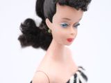 a close up of a doll with a black and white dress