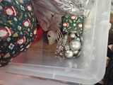 a plastic container filled with christmas ornaments on the floor