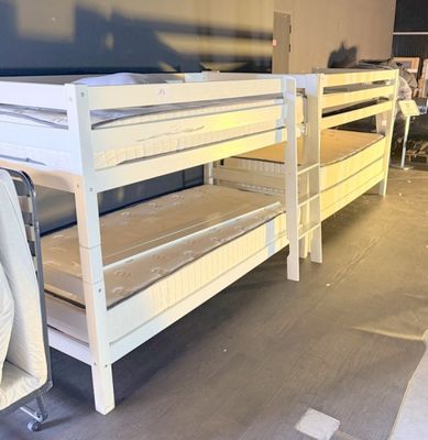 two bunk beds in a room with a tv on the wall