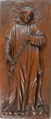 a close up of a wooden plaque with a statue of a man holding a cross