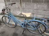 a blue bicycle that is parked next to a brick wall