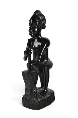 figurine noire représentant un homme assis sur un rocher, coiffé d'un chapeau