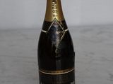 bottle of champagne sitting on a marble counter top with a white wall in the background
