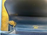 the inside of a blue purse with a gold chain hanging from it