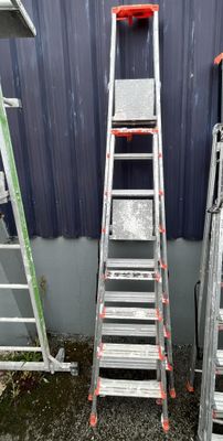 two ladders next to each other in front of a building