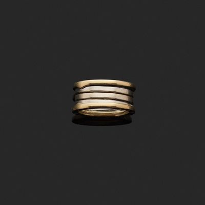 un gros plan d'une bague en or et en argent sur fond noir