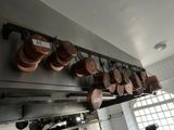 pots and pans hanging from the ceiling of a kitchen