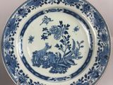 two blue and white plates with flowers and birds on them