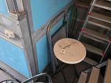 a ladder and a chair next to a blue wall
