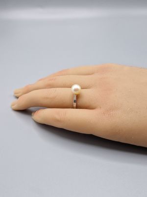 quelqu'un porte une bague ornée d'une perle