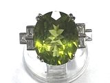 une image d'une bague avec une pierre verte entourée de diamants
