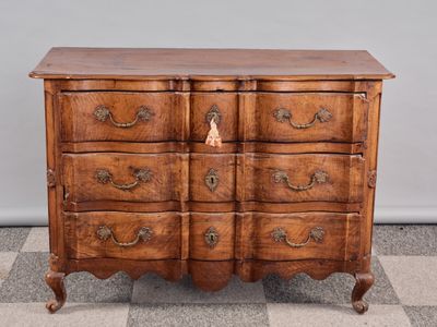 une commode ancienne posée sur un sol en damier