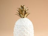 un vase blanc surmonté d'un ananas