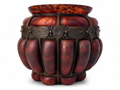 un vase en bois muni d'une poignée en métal