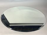a round mirror on the wall above a sink