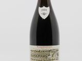 a bottle of red wine sitting on top of a white table